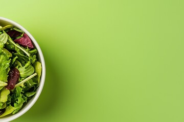 Fresh salad in recyclable bowl on vibrant green background for eco-friendly living
