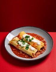 Mexican food enchiladas in plate on red background