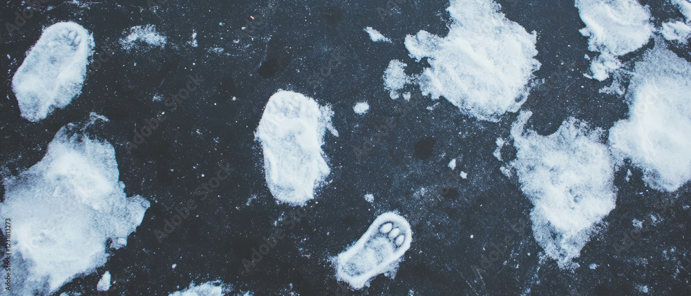 Poster footprints create intricate patterns on snow-covered ground against a dark backdrop