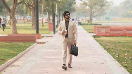 Indian Businessman Walking Holding Coffee and Briefcase