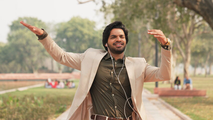 Happy Indian Businessman Listening to Music and Dancing While Walking