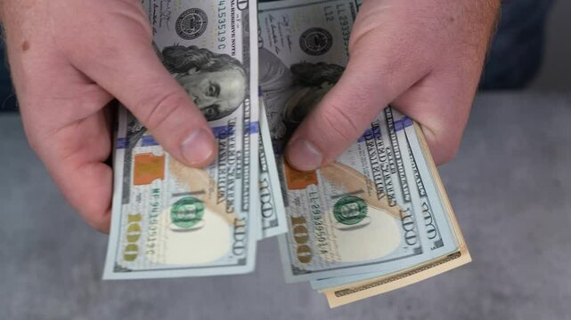 Man is countiong cash money. Dollars. Finance and accounting, calculating return on investment, company budget planning