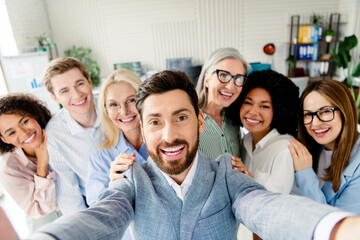 Smiling professional team taking a selfie showcasing workplace collaboration and diversity