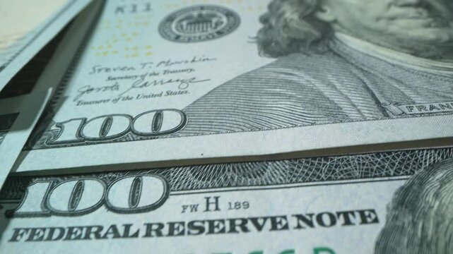 Macro shot of US Dollars. Money Background.Portrait of Benjamin Franklin closeup on the bills for a hundred dollars. Dollars, money close up. 4k footage