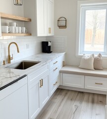 Bright white kitchen with marble countertops, gold hardware, and built-in bench.