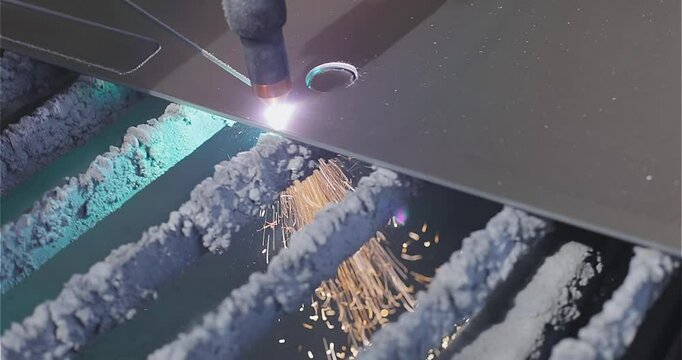 The plasma cutter will cut the part. Plasma cutting. Plasma cutter work at the factory. The process of cutting a metal part with a plasma cutter