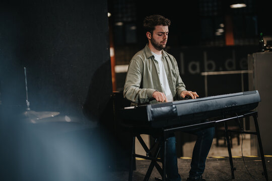 Musician passionately playing the keyboard on stage with concentration, showcasing artistic performance.