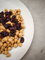 Chickpeas and dried cranberries are combined on a white plate, offering a nutritious and flavorful culinary experience healthy dinner for Galentines day