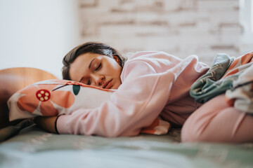 A young woman peacefully sleeping in a cozy bedroom. Soft lighting enhances the tranquil...