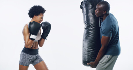 Woman, man and boxing coach with punching bag, support or training for fitness by white background. African people, exercise and mentor with martial arts equipment, power or combat sport in studio