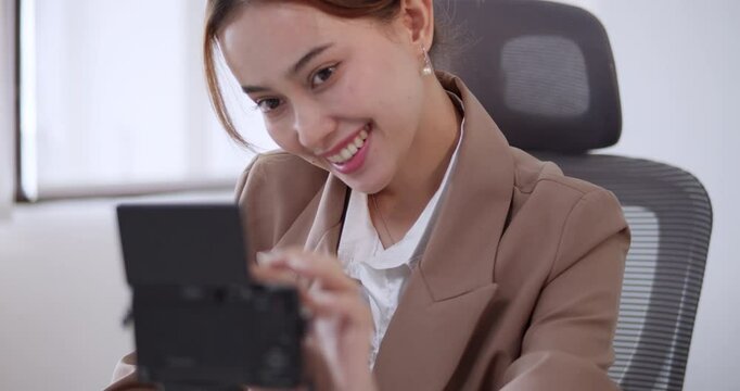 A woman influencer setting up her camera and waves to her followers and listeners online.