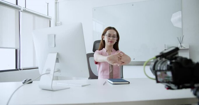 Stretching out her arms and hands, a corporate woman is trying to relive the stress she is feeling.