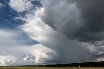 A huge rain cloud over fields in the countryside