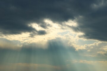 雲のすき間から漏れる厳かな光　カーテンのひだのような　河川冬の夕方