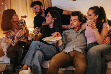 A group of young friends celebrate a birthday party at home, sharing laughter and snacks in a warm...