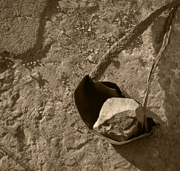 An antique leather sling lies on the ground