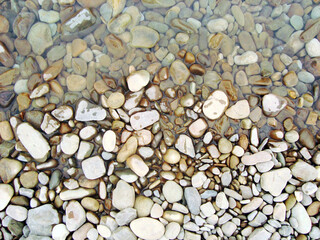 white brown gray wet small pebbles near the water shore, wet stones gravel shore coast river sea, stone beach background wallpaper
