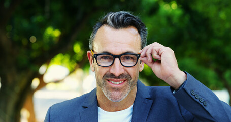 Mature, portrait and happy man with glasses in nature for business tour, sight or optometry. Face, male person or NGO executive with smile for good eyesight, visual aid or perception at outdoor park