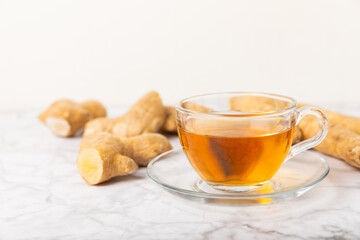 Cup of hot ginger tea with slices of ginger root on wooden background. Warming drink. Alternative medicine. Tea with honey, lemon, ginger and mint. Space for text. Copy space