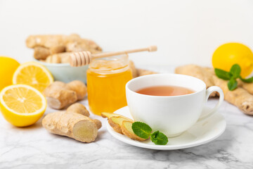 Cup of hot ginger tea with slices of ginger root on wooden background. Warming drink. Alternative medicine. Tea with honey, lemon, ginger and mint. Space for text. Copy space