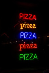 Colorful neon signs of pizza illuminated at night, Turin, Italy