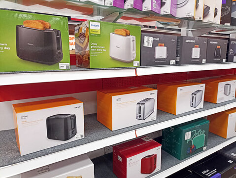 Appliance store shelf displaying various brands of toasters in colorful packaging boxes