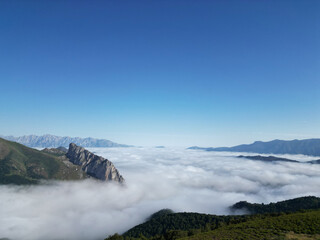 Breathtaking sea of clouds covering mountain valley under blue sky
