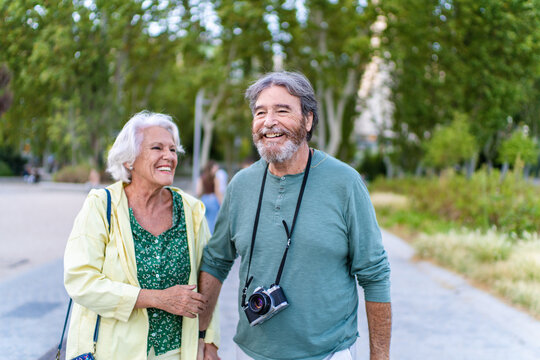 Happy senior couple walking and smiling in a park
