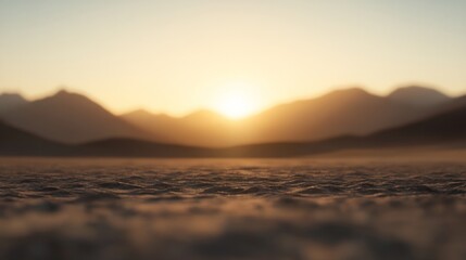 Fototapeta premium Sunset over a vast, flat desert landscape with mountains in the distance.