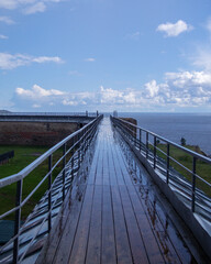 Obraz premium Calm reflections on a rainy day at the coastal boardwalk near the ocean