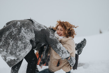 Close-up of two individuals interacting joyfully in the snow, showcasing winter outdoor fun and...