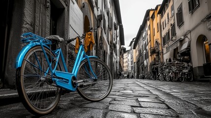 A retro blue bicycle adds a splash of color to the black-and-white scene of an old town street in Florence, Italy, creating a vintage-style image. 