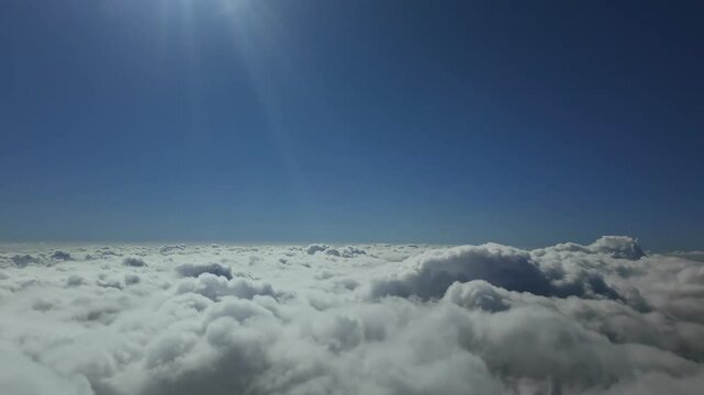 An immersive view of a flight above and through the clouds at hypersonic speed though the pilot&rsquo;s eyes under a blue sky with the sun shining above. 4K. Hyperlapse.