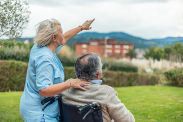 Compassionate nurse assisting elderly man outdoors 