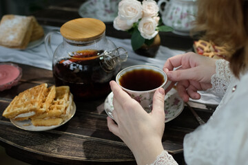 Tea party. Woman drinking black tea during breakfast