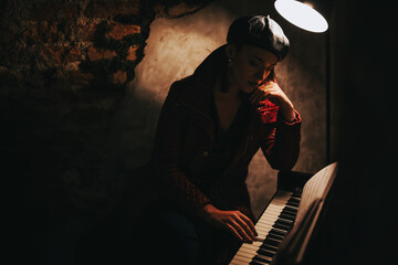 A contemplative woman in a leather beret plays piano under soft lighting. The moody atmosphere...