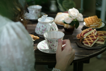 Tea party. Woman drinking tea from porcelain tea cup