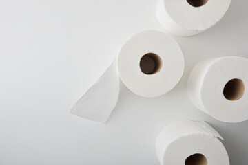 Background with four rolls of perforated white toilet paper top