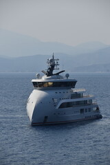Obraz premium A white modern luxury yacht in a small port in the Mediterranean Sea, Greece