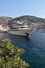 A white modern luxury yacht in a small port in the Mediterranean Sea, Greece