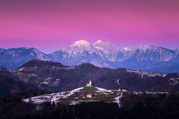 A church on the hill in patchy snowy conditions in the sunset