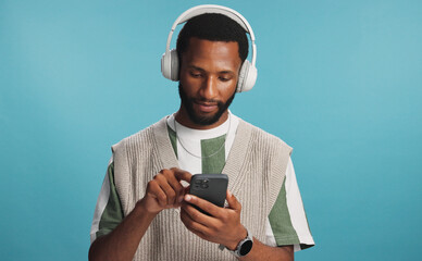 Headphones, phone and black man in studio with music, playlist or album for review on blog. Type,...