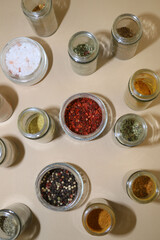 set of different spices in glass jars. paprika, pepper, turmeric, chili, dry basil and others
