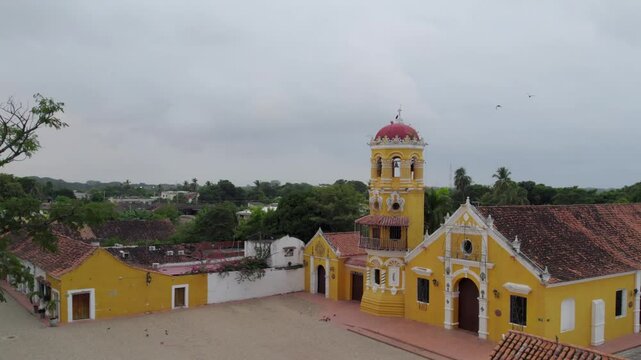 Mompox 191223 Sub_74
Mompox,  Santa B&aacute;rbara Church. 
 As the throttle increases, the camera smoothly ascends, revealing the church&rsquo;s striking baroque-style fa&ccedil;ade, adorned with its iconic white and ye