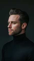 Obraz premium In a dimly lit interior, a modern man with slicked-back jet-black hair poses thoughtfully. Wearing a fitted turtleneck, he embodies sophistication and calmness, lost in deep contemplation