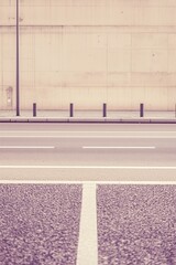 Empty road with tall concrete wall in background Minimalist urban scene