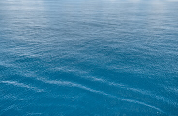 Serene ocean surface soft waves ripples creating peaceful calming texture. nature seascape themes backgrounds, tranquil sea marine elements. relaxation meditation