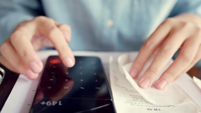 A person is using a calculator to add up numbers. The calculator has the numbers 9, 3, and 2 on it