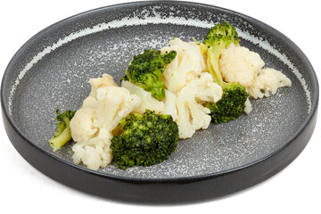 Boiled broccoli and white cauliflower on a plate on a white background