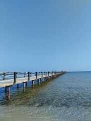  long pontoon bridge extending into the sea, open sea, sea coast, deserted beach without people,...